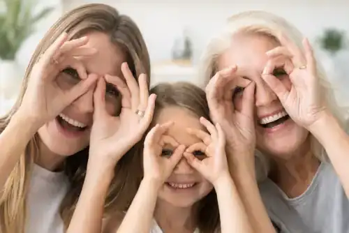 Family smiling and making playful eye shapes with their hands