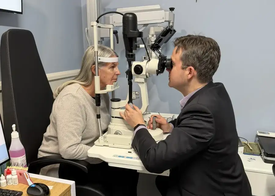 Leigh Plowman examining a patient’s eyes with a slit lamp